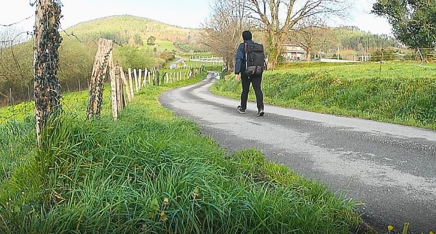 Íñigo caminando por una pista hacia el Alto del Fresno, en el Camino Primitivo